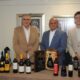 Rafael Delgado, Iván de Jesús García y Rafael Jaén junto a la variedad de vinos producidos por Bodegas Pérez Barquero en España.